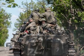 Service members of pro-Russian troops are seen atop an armoured vehicle on a road in the course of Ukraine-Russia conflict near Mariupol in the Donetsk region, Ukraine May 20, 2022. 