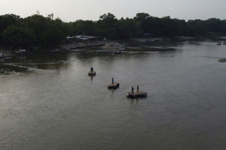 Undocumented migrants cross the Suchiate River that separates Guatemala from Mexico