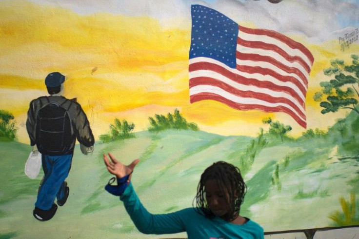 A Haitian migrant is seen next to a painting of a US flag outside a migrant shelter in Mexico on May 20, 2022