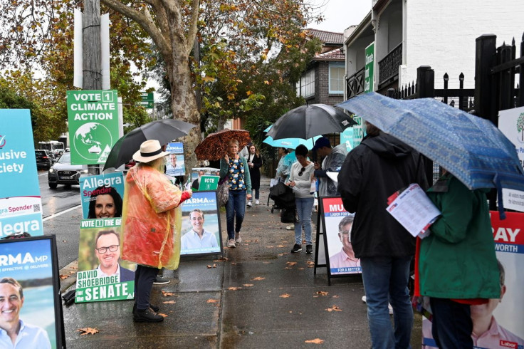 Voters line up outside in the rain at the Waverley suburb polling station to cast their ballots on the day of the national election in Sydney, Australia, May 21, 2022.  