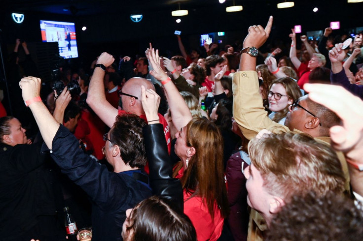 Supporters react to election updates broadcasted on a screen while they wait for Anthony Albanese, leader of Australia's Labor Party, to speak about the outcome of the country's general election in which he ran against incumbent Prime Minister and Liberal