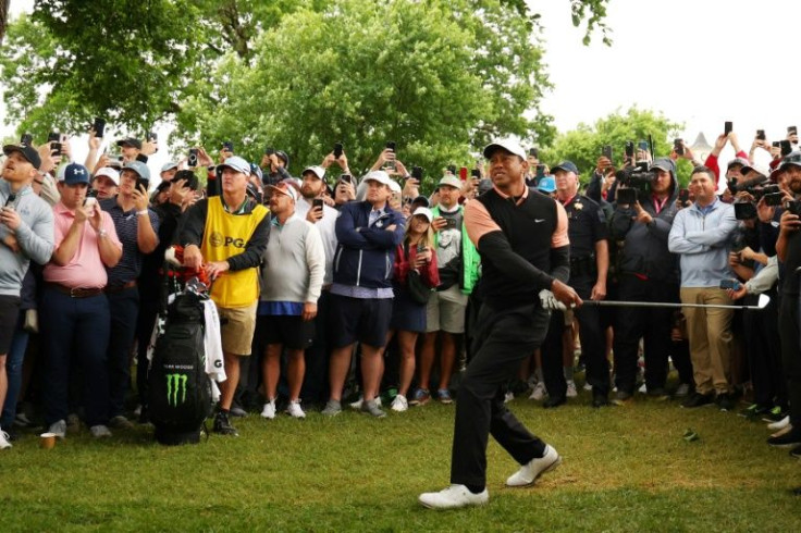 Tiger Woods blasts a shot from the rough during Saturday's third round of the PGA Championship at rain-hit Southern Hills