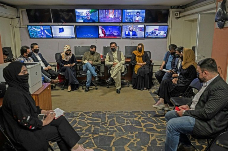 Reporters for Tolonews cover their faces as they attend an editorial meeting in Kabul on Sunday