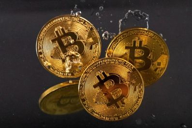 Souvenir tokens representing cryptocurrency Bitcoin plunge into water in this illustration taken May 17, 2022. 
