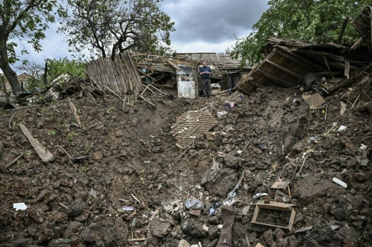 A crater the size of an open-pit mine stands in place of a vegetable garden, destroyed by a missile strike on a residential district of east Ukraine's Bakhmut
