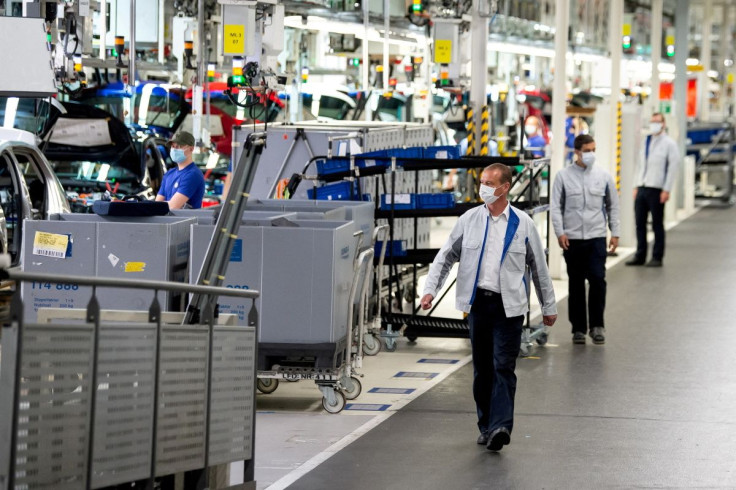 Staff wear protective masks at the Volkswagen assembly line in Wolfsburg, Germany, April 27, 2020. Swen Pfoertner/Pool via