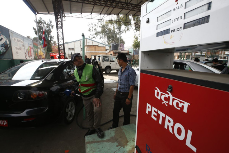 A petrol pump attendant (L) fills petrol on a car at Saja Petrol pump in Kathmandu, Nepal, January 27, 2016. 