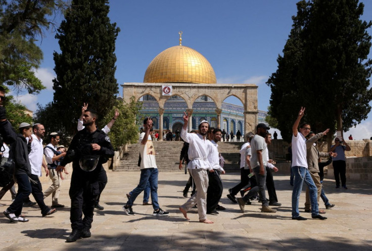 Jewish visitors gesture as Israeli security forces secure the area at the compound that houses Al-Aqsa Mosque, known to Muslims as Noble Sanctuary and to Jews as Temple Mount, in Jerusalem's Old City, May 5, 2022.