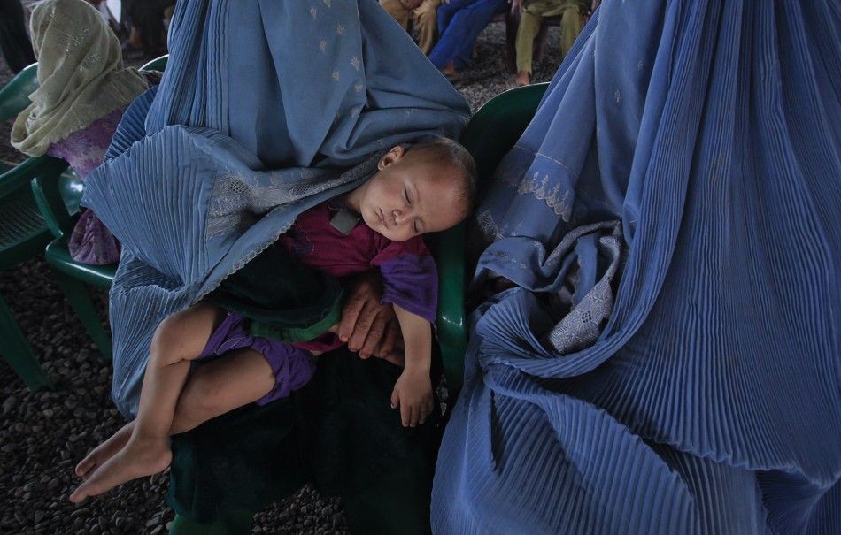 A child sleeps while Afghan refugees wait to be repatriated from a centre in Peshawar