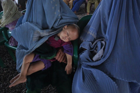 A child sleeps while Afghan refugees wait to be repatriated from a centre in Peshawar