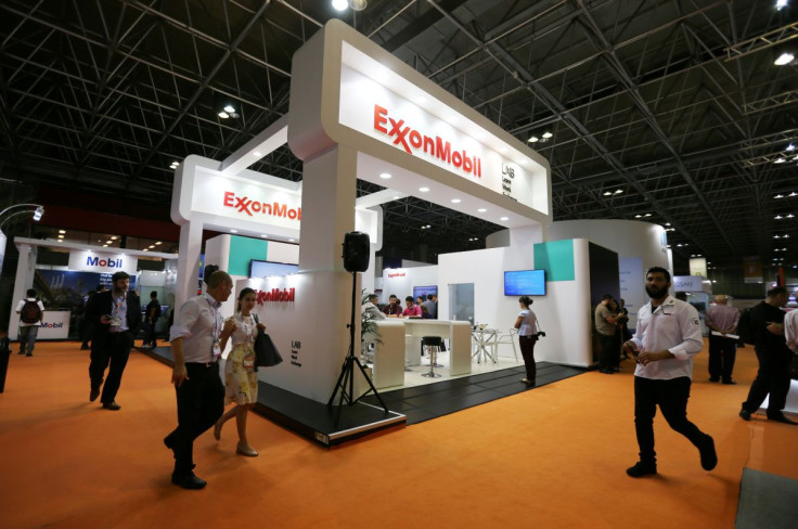 FILE PHOTO - People walk near the booth of the Exxon Mobil Corp at the Rio Oil and Gas Expo and Conference in Rio de Janeiro, Brazil September 24, 2018.