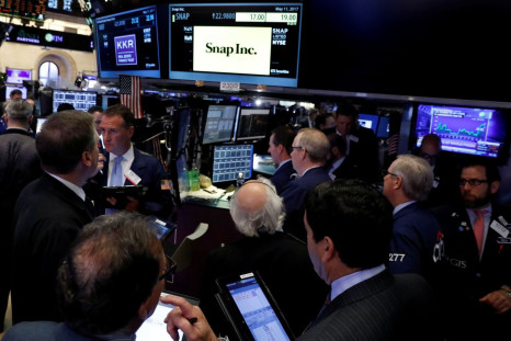 FILE PHOTO - Traders gather at the post where Snap Inc. is traded, just before the opening bell on the floor of the New York Stock Exchange (NYSE) in New York, U.S., May 11, 2017. 