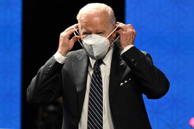 US President Joe Biden adjusts his mask as he launches an Asia-wide trade framework in Tokyo