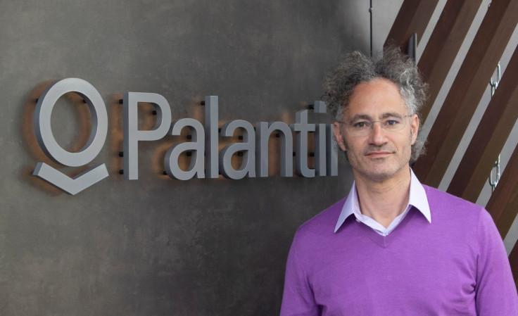 Alex Karp, CEO of Palantir Technologies poses beside the company's logo ahead of an interview with Reuters in the Alpine resort of Davos, Switzerland May 23, 2022.