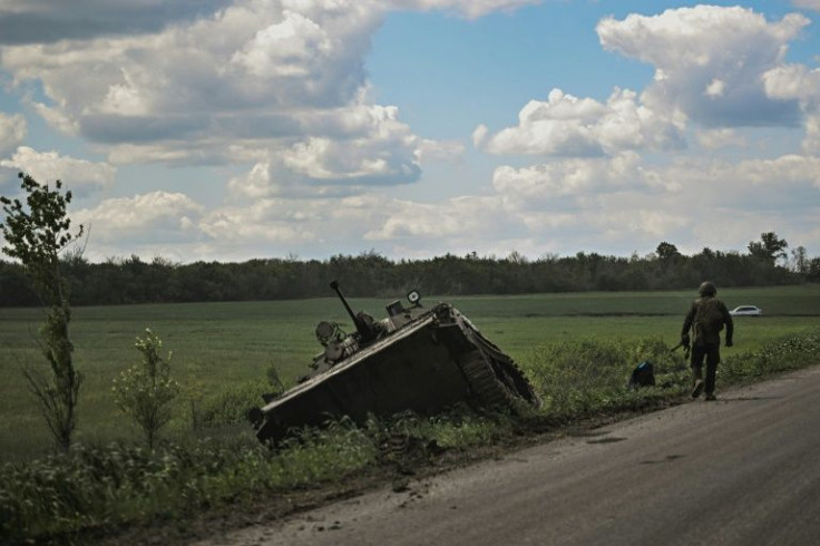 The charred remains of Ukrainian military vehicle litter a road under assault from Russian forces trying to cut off a swathe of the eastern front