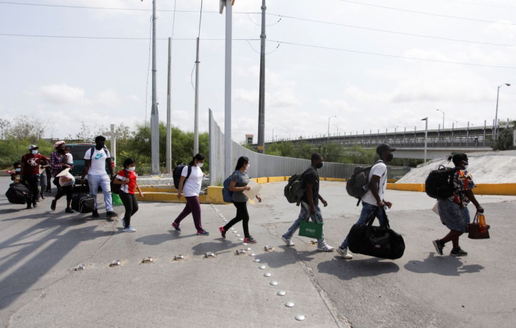 Migrants walk across the Reynosa-Hidalgo International Border Bridge after staying in Mexico under the coronavirus disease (COVID-19) restrictions known as Title 42 and being accepted by the U.S. government with legal assistance, in Reynosa, Mexico May 23