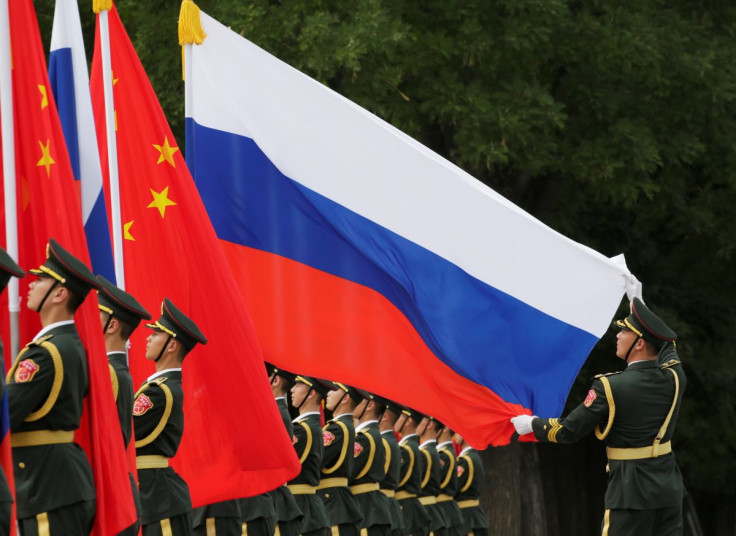 A military officer adjusts a Russian flag ahead of a welcome ceremony hosted by Chinese President Xi Jinping for Russian President Vladimir Putin outside the Great Hall of the People in Beijing, China June 8, 2018. 