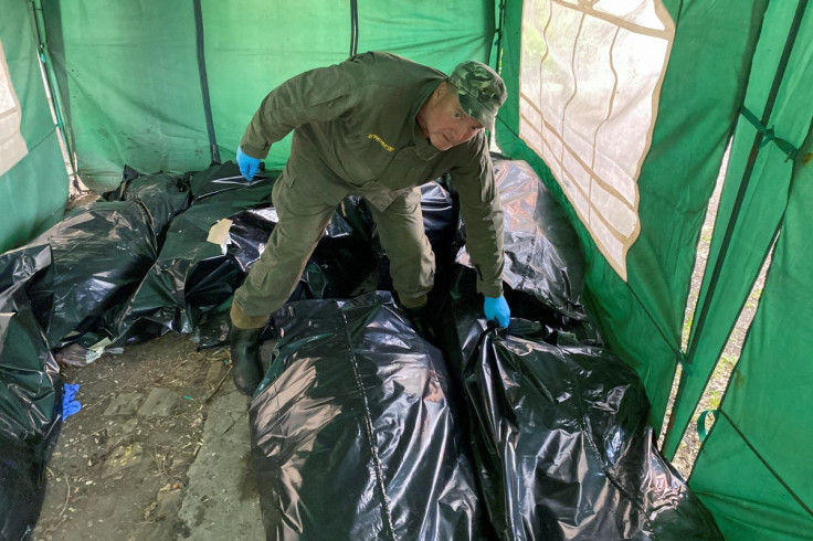 Seorang pekerja ritual mengambil jenazah tentara Rusia yang terbunuh sebelum memuatnya ke gerbong berpendingin, saat serangan Rusia terhadap Ukraina berlanjut, di kompleks kamar mayat di Kharkiv, Ukraina 22 Mei 2022.  