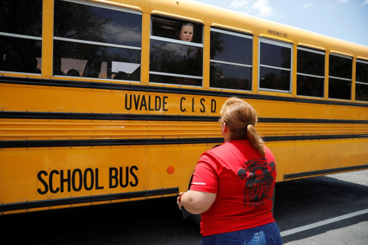A school employee talks through the window of a school bus to one of the parents near the scene of a suspected shooting near Robb Elementary School in Uvalde, Texas, U.S. May 24, 2022.  