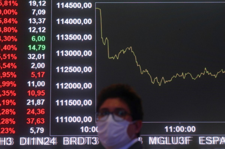 A man is seen in front of an electronic board showing the graph of the recent fluctuations of market indices on the floor of Brazil's B3 Stock Exchange in Sao Paulo, Brazil October 19, 2021. 