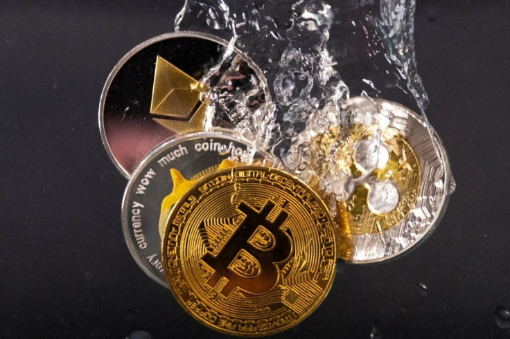 Souvenir tokens representing cryptocurrency networks Bitcoin, Ethereum, Dogecoin and Ripple plunge into water in this illustration taken May 17, 2022. 