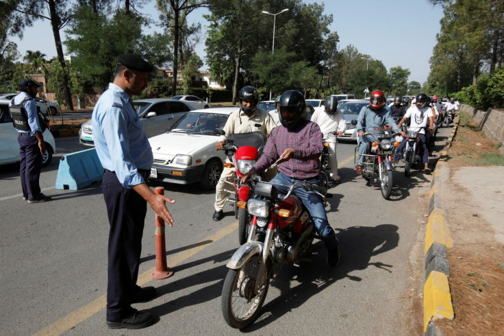 Police officers check identity passes of the commuters entering Red Zone for their offices, ahead of the planned protest march towards Islamabad led by ousted Prime Minister Imran Khan, in Islamabad, Pakistan May 25, 2022. 