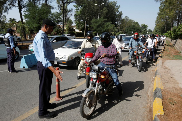 Police officers check identity passes of the commuters entering Red Zone for their offices, ahead of the planned protest march towards Islamabad led by ousted Prime Minister Imran Khan, in Islamabad, Pakistan May 25, 2022.