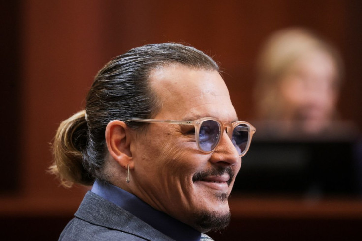 Actor Johnny Depp reacts while clinical and forensic psychologist Dr Shannon Curry testifies during his defamation trial against his ex-wife Amber Heard, at the Fairfax County Circuit Courthouse in Fairfax, Virginia, U.S., May 25, 2022.