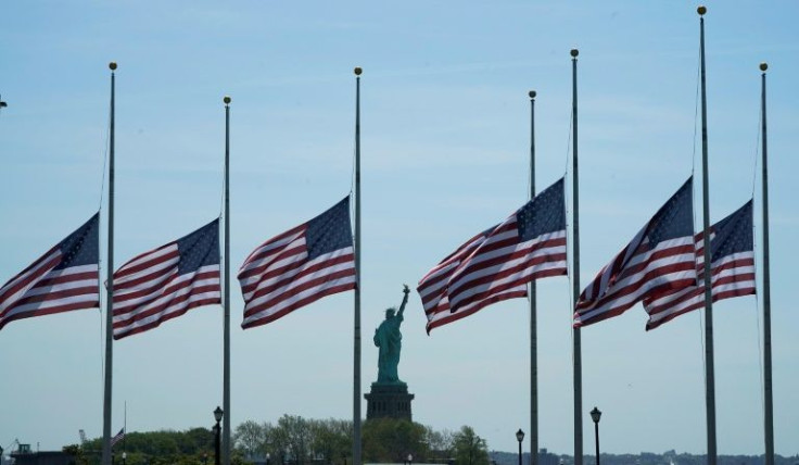 US flags fly at half staff in view of the Statue of Liberty following a school massacre in Texas