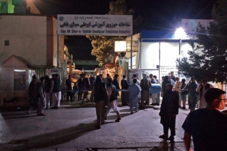 Relatives of bomb blasts victims gather outside a hospital in Mazar-i-Sharif on May 25, 2022 after three bombs ripped through minibuses in the city