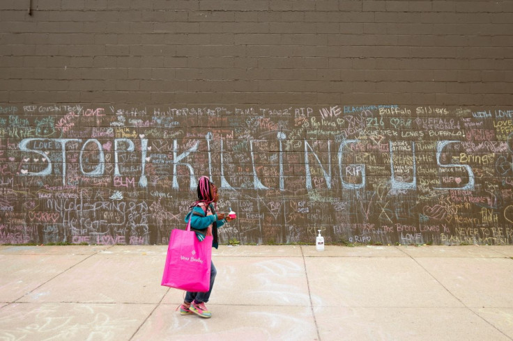 A child walks past a memorial at the scene of the shooting at a Tops supermarket in Buffalo, New York, May 20, 2022.  