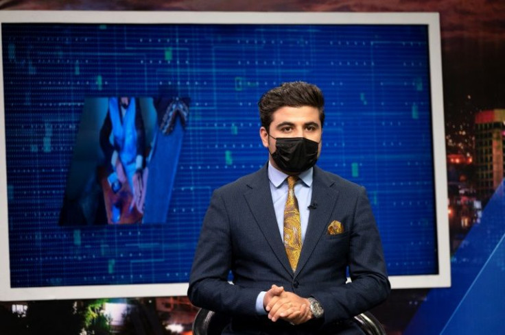 Nisar Nabil, presenter for TOLOnews, wearing a black mask speaks during a live broadcast at Tolo TV station in Kabul on May 25, 2022