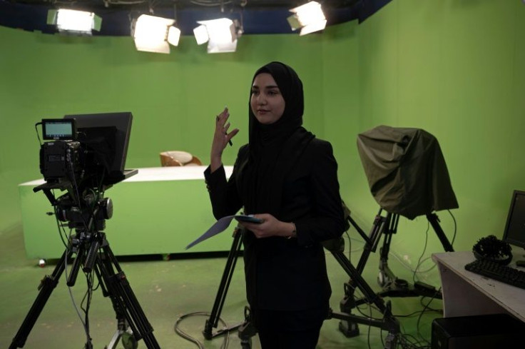 An Afghan female presenter for 1TV channel, Masheed Barzz, presents the news with her face covered by a veil during a live broadcast at 1TV channel station in Kabul on May 25, 2022