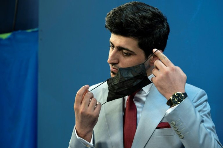 1TV channel's editor-in-chief Idrees Faroqi, wears a black mask as a symbolic protest against the Taliban authorities for ordering women presenters to cover their faces on air, during an interview with AFP at 1TV channel station in Kabul on May 25, 2022