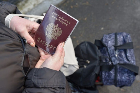 A woman holds a Russian passport as she waits for evacuation in the Ukrainian city of Donetsk on February 19, 2022