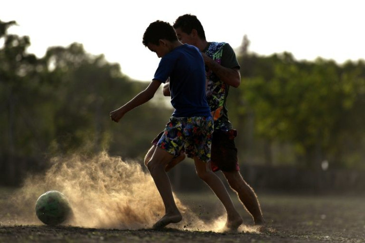 Children play football on a dusty field in Barrancas, the home town of Liverpool's Colombian star Luis Diaz