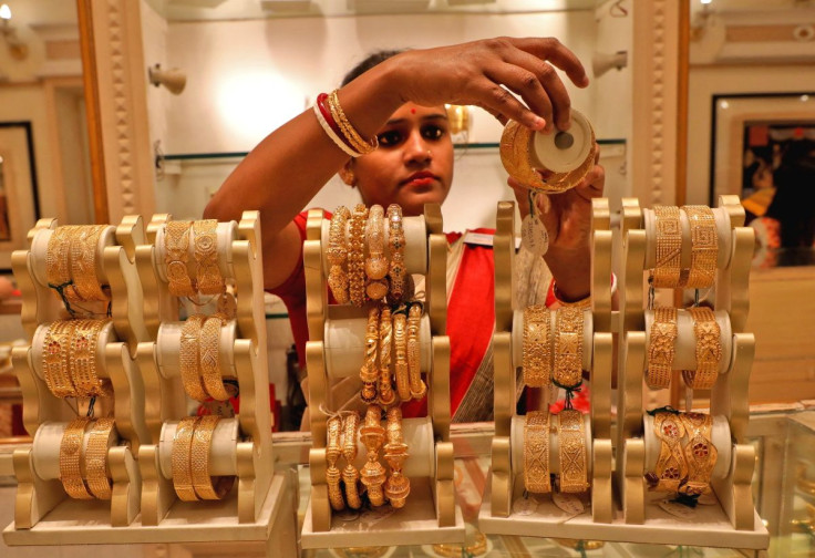 A saleswoman shows gold bangles to a customer at a jewellery showroom on the occasion of Akshaya Tritiya, a major gold buying festival, in Kolkata, India, May 3, 2022. 