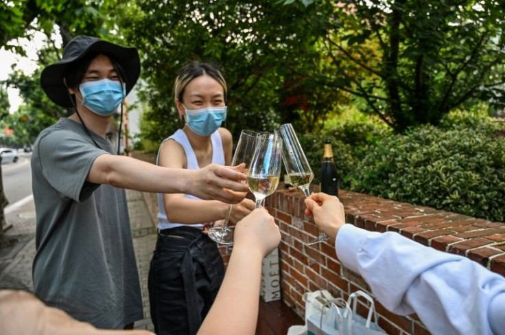 A masked quartet of friends toasted their brief freedom with champagne in Shanghai