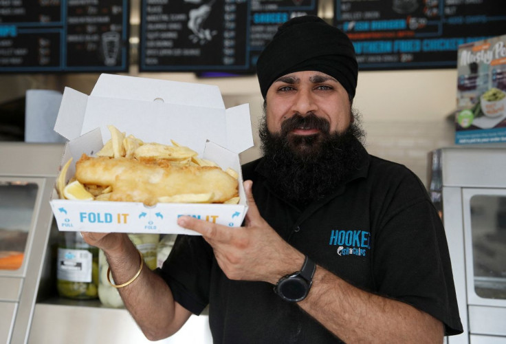 Owner of Hooked Fish and Chips shop, Bally Singh, holds a portion of fish and chips at his take-away in West Drayton, Britain, May 25, 2022. Picture taken May 25, 2022.