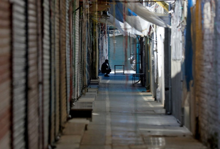 A man sits in front of closed shops during the second day of protesting against the sentencing of Kashmiri separatist leader Yasin Malik, Chairman of Jammu Kashmir Liberation Front (JKLF), near his residence in Srinagar May 26, 2022.