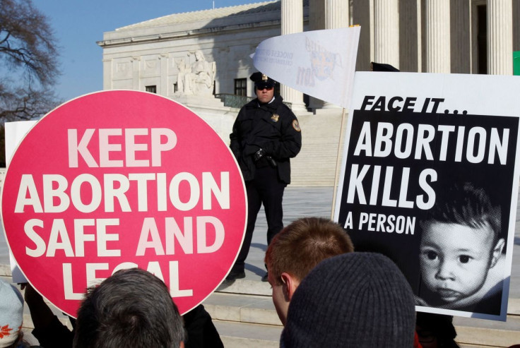 A police officer watches pro-life and pro-choice supporters demonstrating to mark the anniversary of the Supreme Court's 1973 Roe v. Wade abortion decision in Washington, January 24, 2011.   