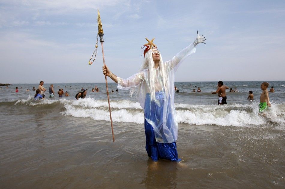 A man wades out of the water after marching during the Mermaid Parade at Coney Island in the Brooklyn section of New York