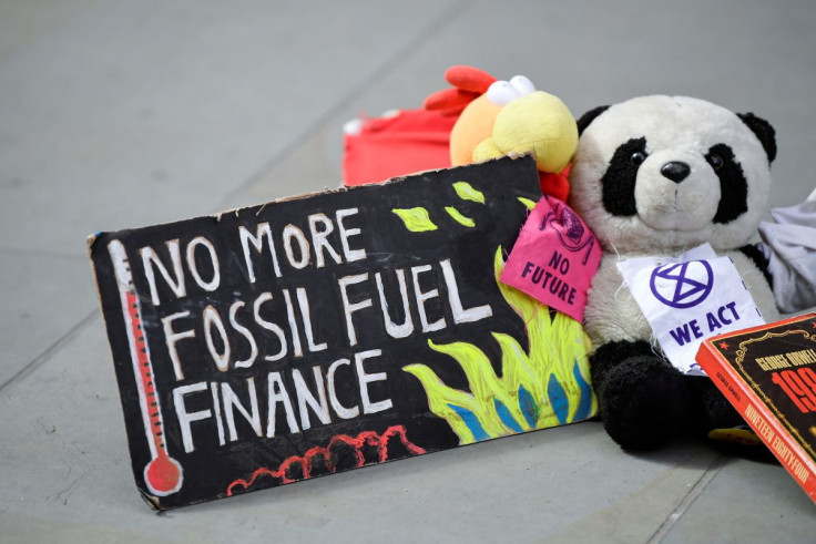 A sign lies on the ground as members of Extinction Rebellion stage a protest against the use of and investment in fossil fuel, outside offices of Vanguard Asset Management on Earth Day in the City of London, Britain, April 22, 2022.