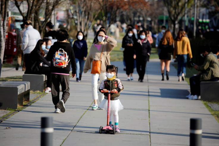 A girl wearing a protective face mask to prevent contracting the coronavirus disease (COVID-19) rides a toy kick scooter at a park in Seoul, South Korea, April 3, 2020.    