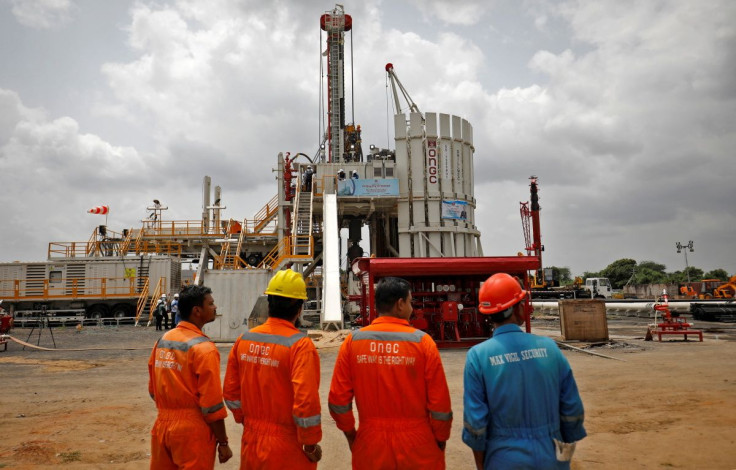 Technicians stand next to an oil rig  at an Oil and Natural Gas Corp (ONGC) plant, during a media tour of the plant in Dhamasna village in the western state of Gujarat, India, August 26, 2021. 