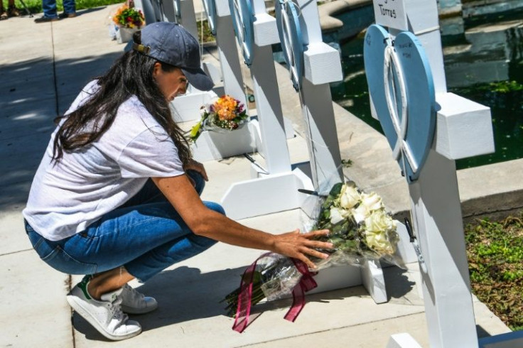 Meghan Markle, the wife of Britain's Prince Harry, places flowers at a memorial in Uvalde, Texas
