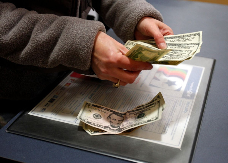 A customer counts her money at the register of a Toys R Us store on the Thanksgiving Day holiday in Manchester, New Hampshire November 22, 2012. 