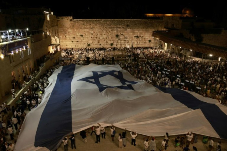 Israelis wave the national flag on the eve of the 'flag march' to mark Jerusalem Day, which commemorates the unification of the city