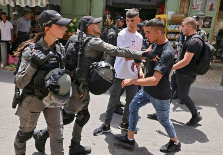 Members of Israeli security scuffle with a Palestinian protester in Jerusalem's Old City, on May 29, 2022