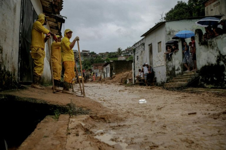 City workers in Recife remove mud from a street, a day after a landslide claimed dozens of lives in the area